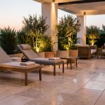 Terrasse professionnelle élégante à l’extérieur, avec mobilier design, plantes en pots et éclairage doux créant une ambiance accueillante.
