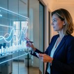 Une directrice financière française analyse un tableau de trésorerie lumineux dans un bureau moderne à l’ambiance professionnelle.