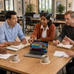 Équipe composée de femmes et d’hommes travaillant ensemble dans un bureau moderne et lumineux, autour de postes de travail variés.